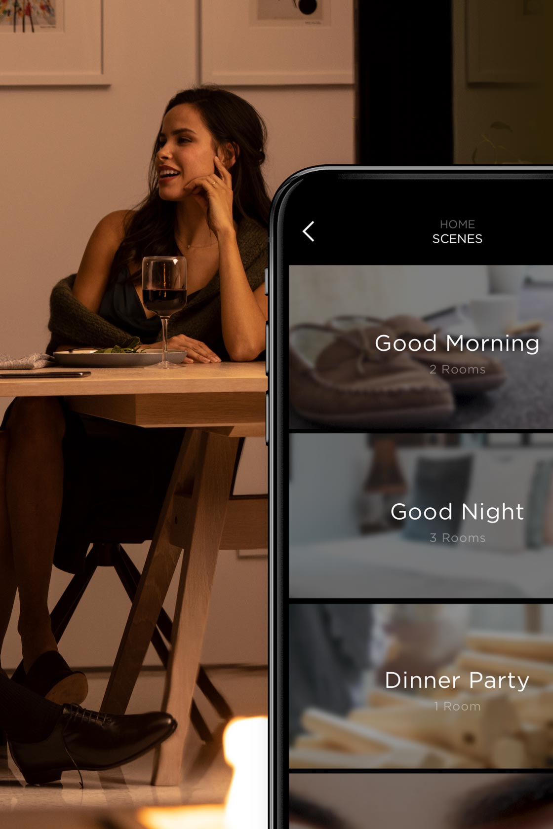Smartphone showing home automation scenes beside a woman at a dining table