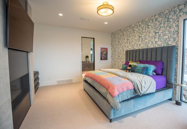 Bedroom with patterned wallpaper and mounted television