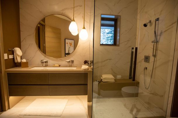 Modern bathroom with walk in glass shower and round mirror