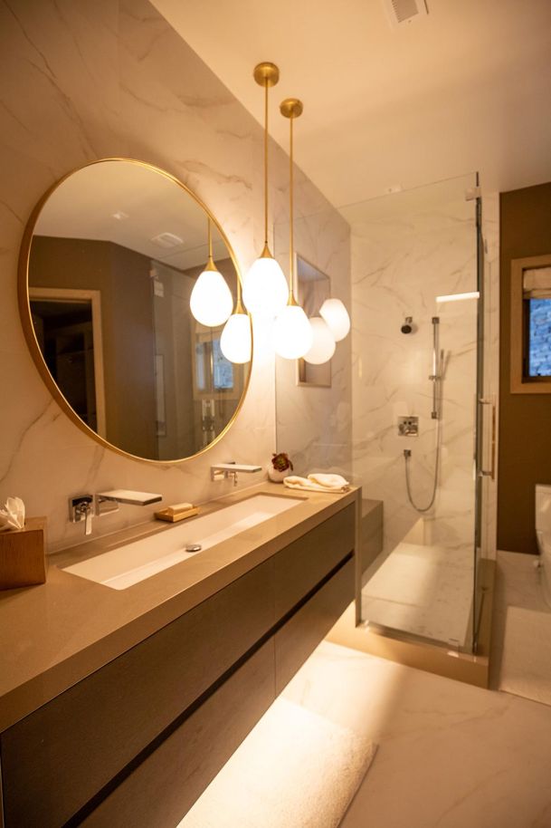 Upscale bathroom with marble tile and hanging globe lights