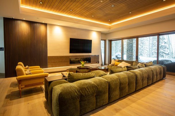 Large green sectional sofa in a room with wood slat walls