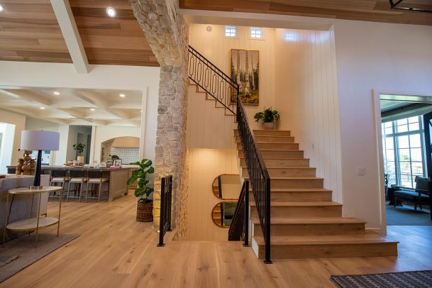 Open foyer with wooden staircase and glass railings