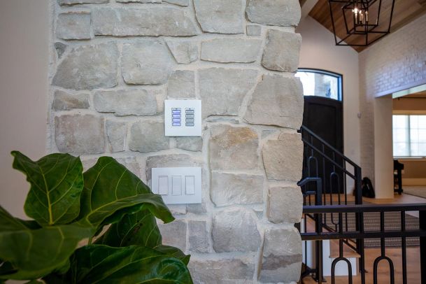 Dual white multi-button smart light switches on stone wall