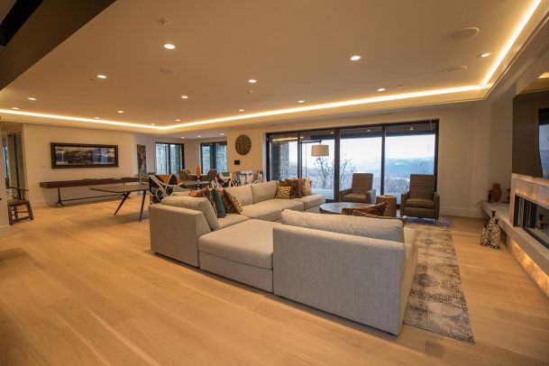 Spacious basement entertainment area with wood floors