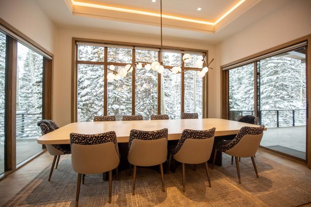 Long dining table with designer branch light fixture