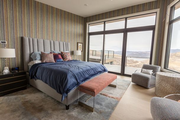Master bedroom with colorful wallpaper and large windows