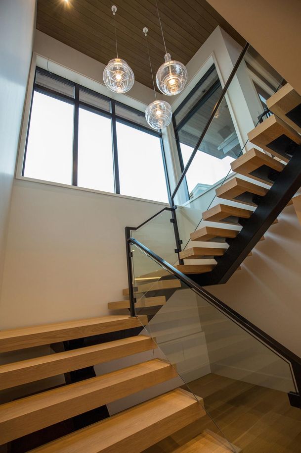 Floating wood staircase with glass globe pendants