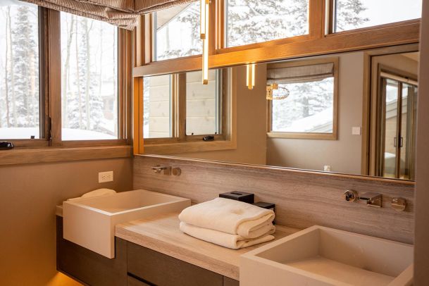 Bathroom vanity with stone sinks and warm pendant lighting