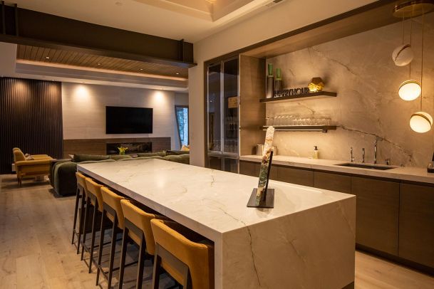 Marble kitchen island with yellow bar stools and bar area
