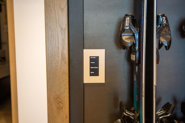 Smart home keypad mounted next to a ski storage rack
