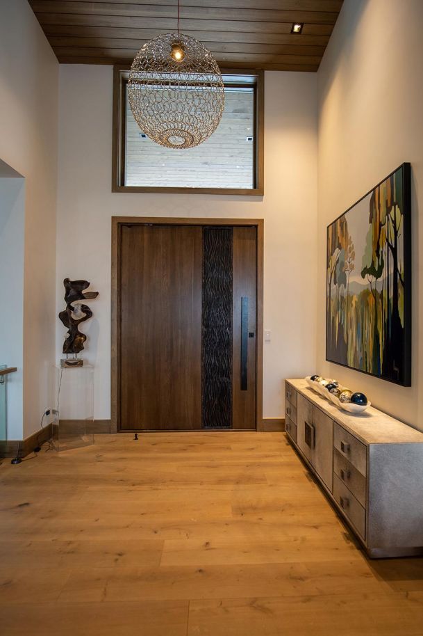 Modern entryway with large wood door and abstract art