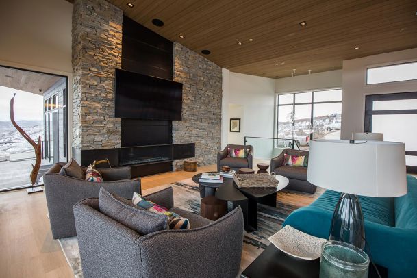 Modern mountain living room with stone walls and teal sofa