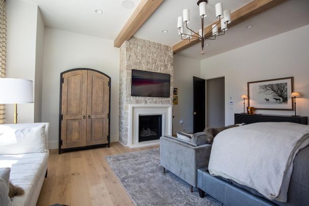 Modern bedroom with stone fireplace and mounted television