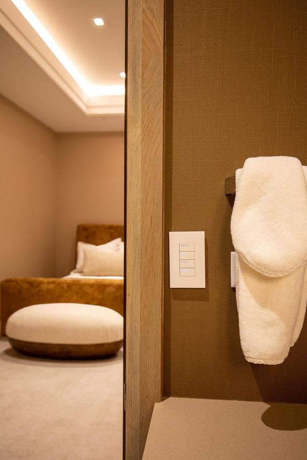 Smart lighting keypad mounted on a textured brown wall