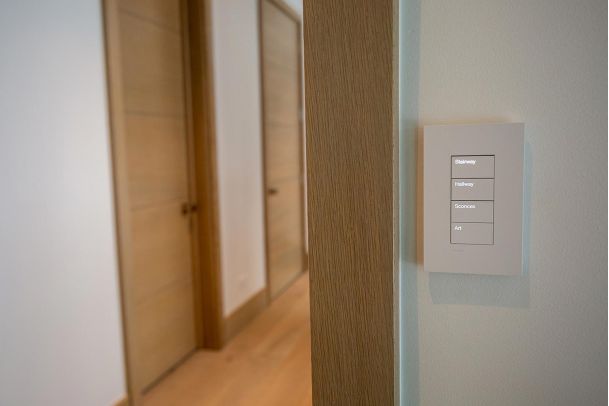 Smart light switch located near a wooden door frame