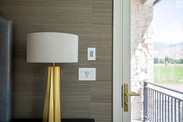 Bedside setup with gold lamp and smart lighting keypad