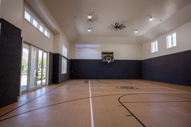 Indoor basketball court with high ceilings and projector