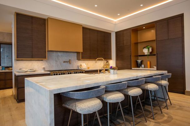 Modern kitchen with marble island and under cabinet lighting