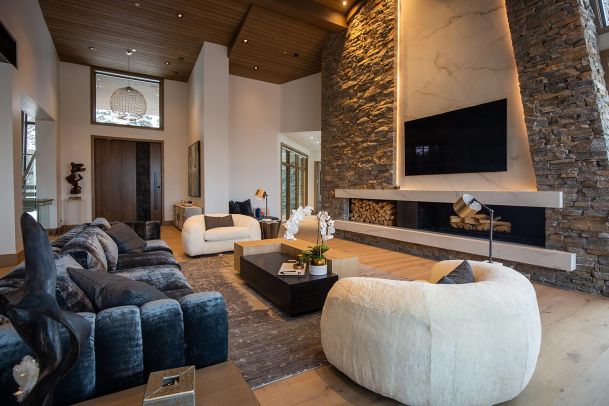Luxury living room with tall stone fireplace and marble accents
