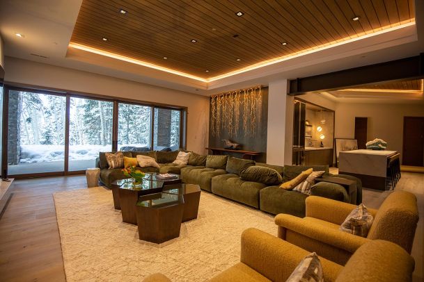 Wide view of modern living space with recessed cove lighting